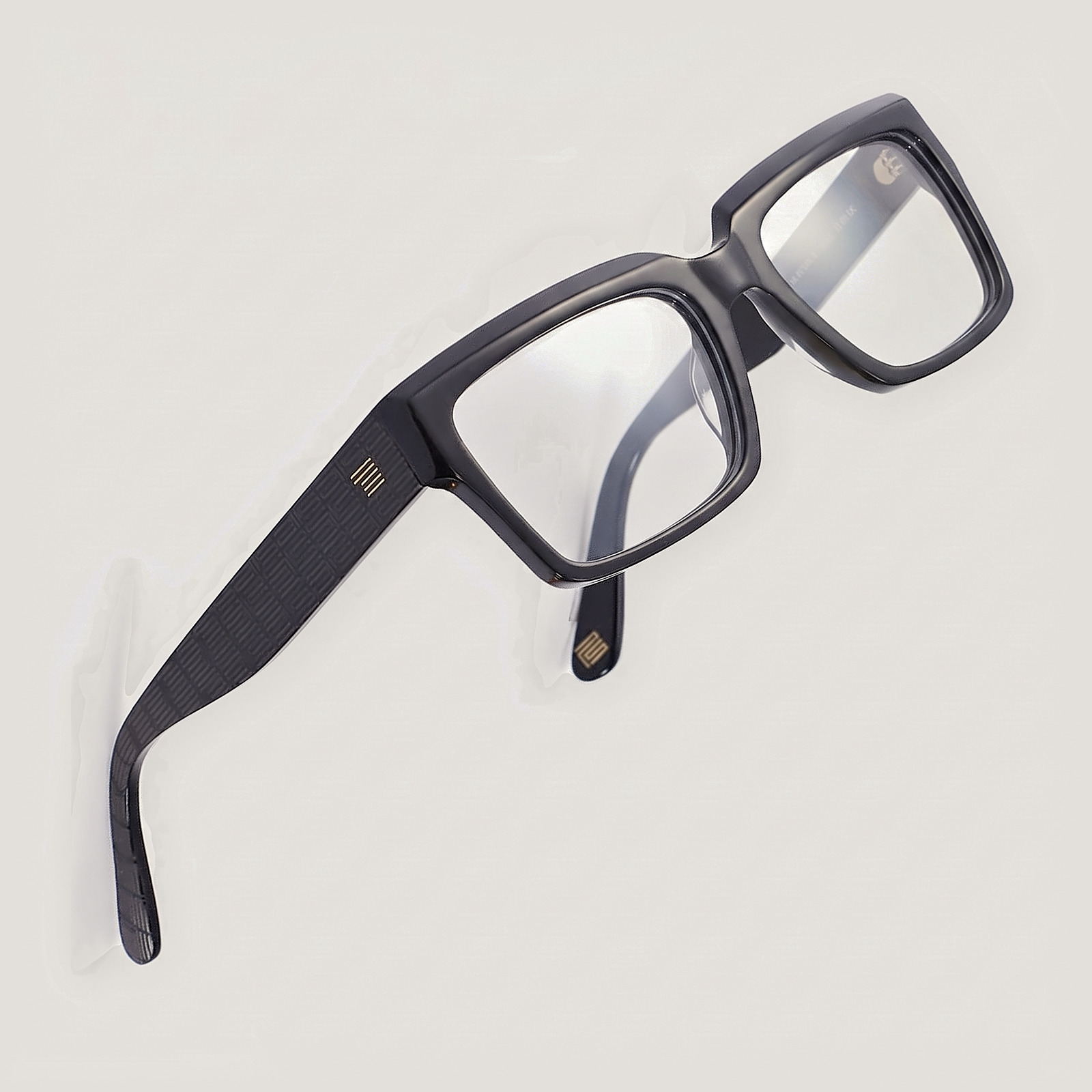 The Square in Noir with clear prescription lenses. The gold PS mark sits on the temple.